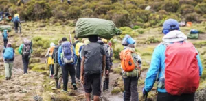 Hiker training on local hills with a heavy backpack, simulating Kilimanjaro conditions