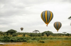 Hot air balloon floating over the Serengeti at dawn on a tailor-made safari in Tanzania